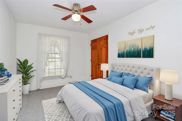 carpeted bedroom featuring ceiling fan and a closet