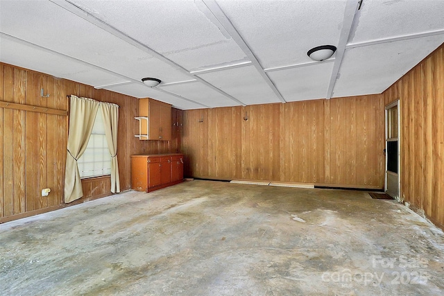 unfurnished room featuring wooden walls