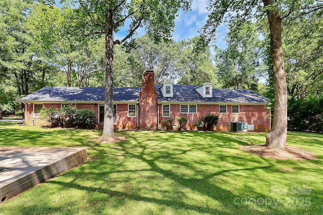 ranch-style home featuring central air condition unit and a front lawn