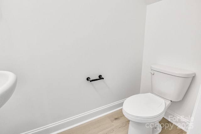 bathroom featuring wood-type flooring and toilet