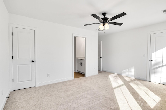 unfurnished bedroom with ensuite bathroom, ceiling fan, and light carpet