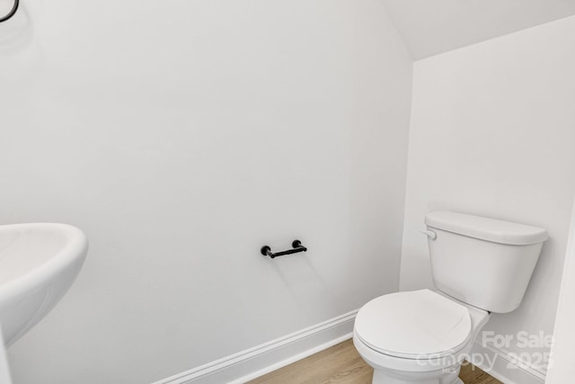 bathroom featuring toilet, vaulted ceiling, and hardwood / wood-style floors