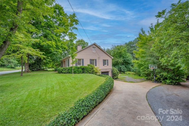 view of side of property featuring a garage and a yard