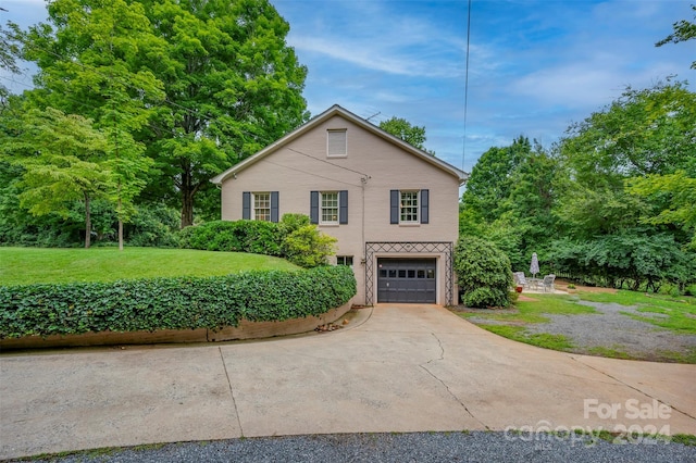 view of front property featuring a garage and a front yard