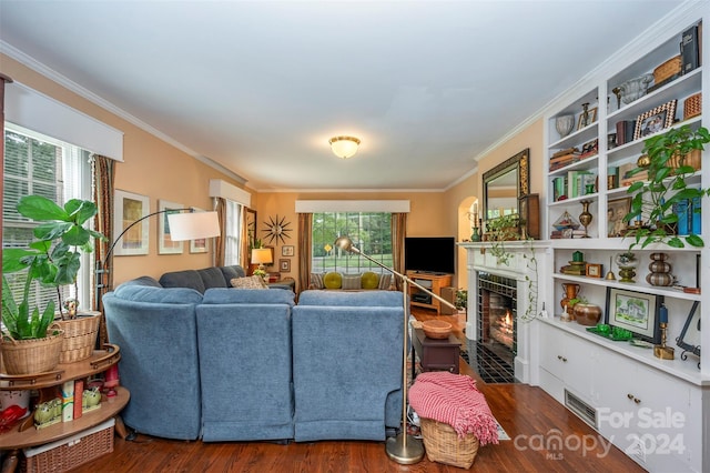 living room featuring a tiled fireplace, a healthy amount of sunlight, and dark hardwood / wood-style flooring