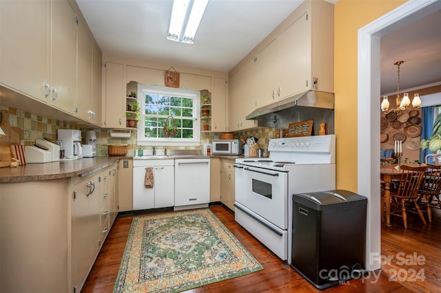 kitchen featuring dark wood-type flooring, sink, tasteful backsplash, a chandelier, and white appliances