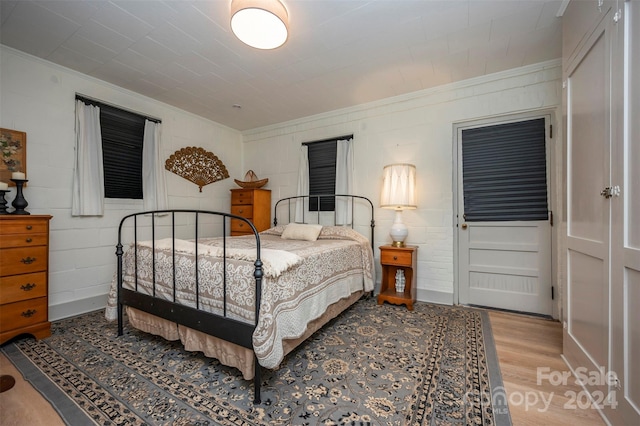 bedroom featuring crown molding and light hardwood / wood-style floors