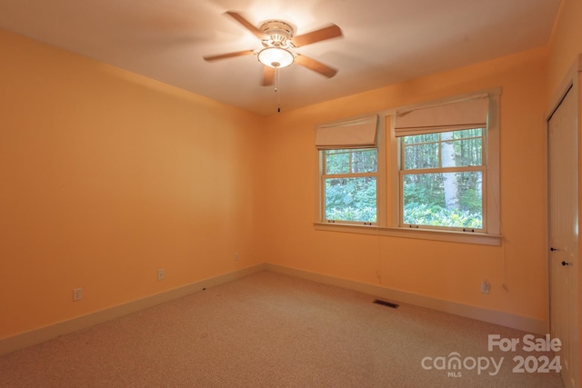 empty room featuring carpet floors and ceiling fan