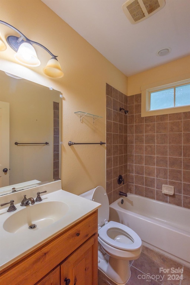 full bathroom featuring tiled shower / bath, vanity, tile patterned floors, and toilet