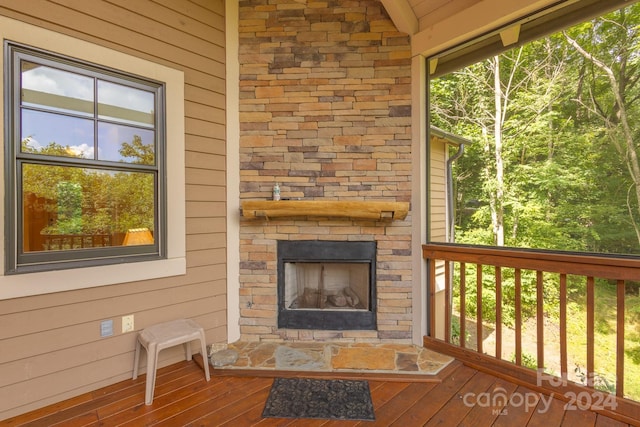 wooden terrace featuring a stone fireplace