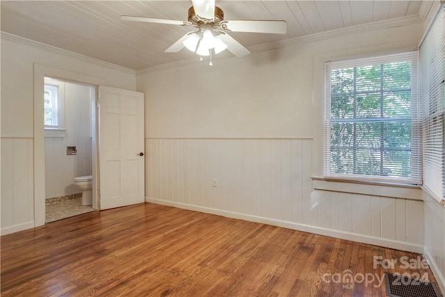 unfurnished bedroom featuring crown molding, multiple windows, hardwood / wood-style floors, and ceiling fan