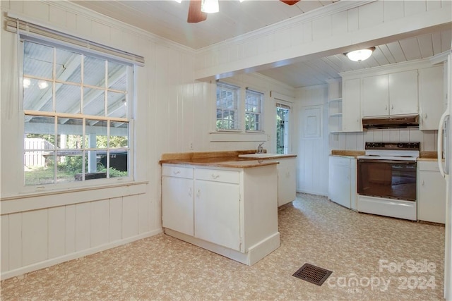 kitchen featuring white electric range, white cabinets, ceiling fan, and a wealth of natural light