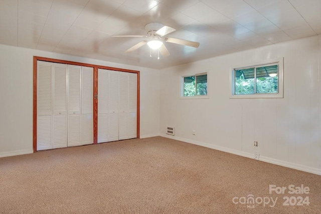 unfurnished bedroom with ceiling fan, carpet, and multiple closets