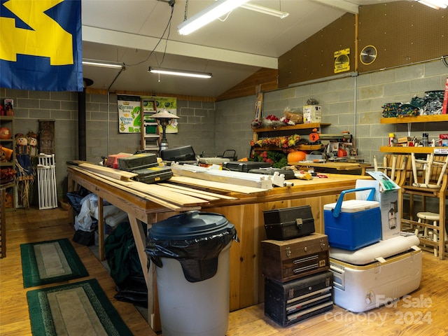 miscellaneous room featuring a workshop area, light hardwood / wood-style floors, and vaulted ceiling