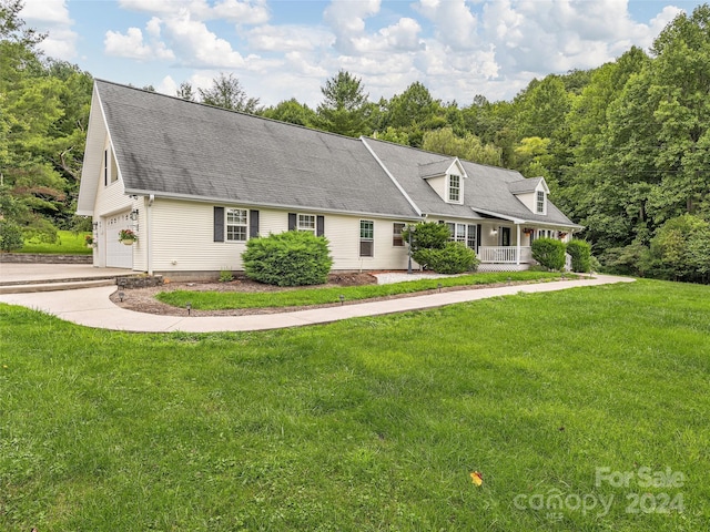 cape cod home with a garage, driveway, a porch, and a front lawn