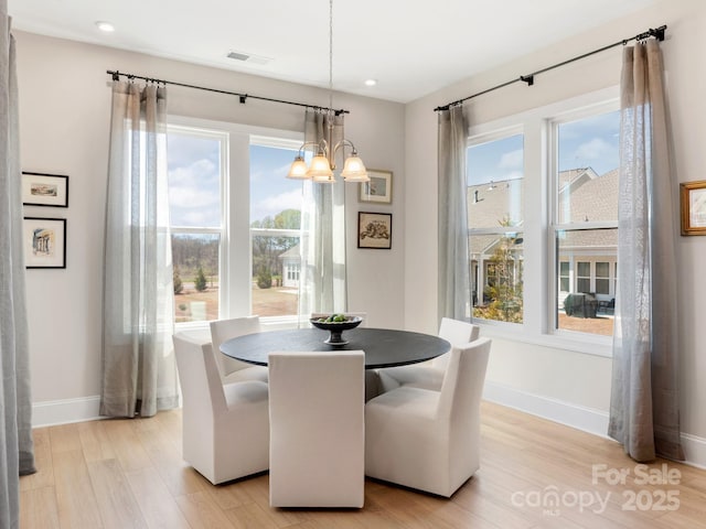 dining area featuring a chandelier and light wood-type flooring