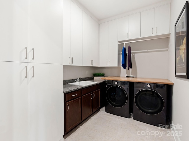 washroom featuring washer and dryer, cabinets, light tile patterned floors, and sink