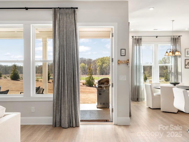 entryway featuring light wood-type flooring and a chandelier