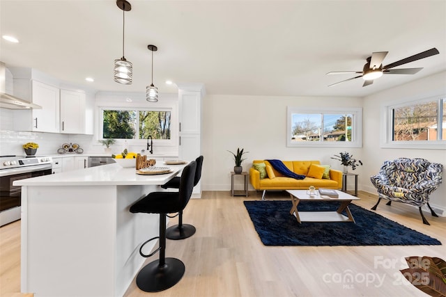 kitchen with white cabinetry, decorative light fixtures, a kitchen breakfast bar, stainless steel appliances, and backsplash