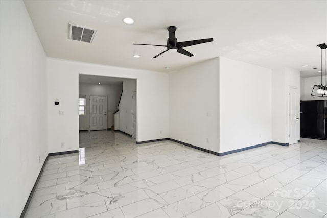 tiled spare room with ceiling fan