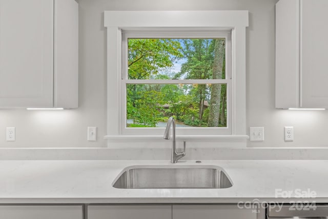 kitchen featuring white cabinetry, plenty of natural light, sink, and light stone counters