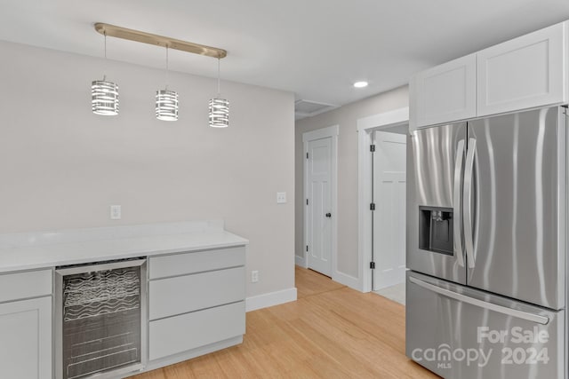 kitchen with white cabinetry, pendant lighting, stainless steel fridge, and beverage cooler