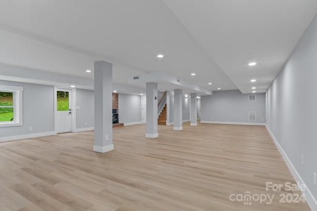 basement with a fireplace and light hardwood / wood-style floors