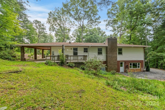 rear view of property with a wooden deck and a yard