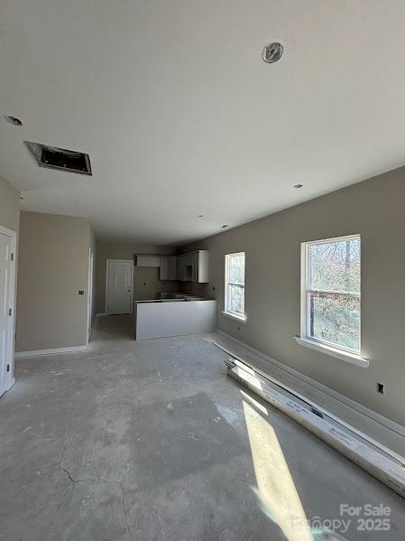 unfurnished living room with concrete floors