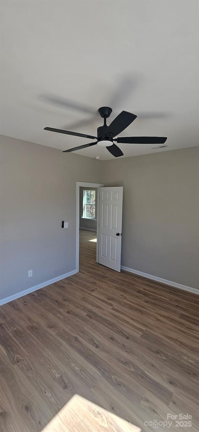 empty room featuring a ceiling fan, baseboards, and wood finished floors