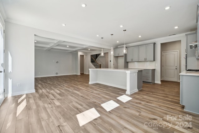 kitchen with light hardwood / wood-style floors, hanging light fixtures, a kitchen island, and gray cabinetry