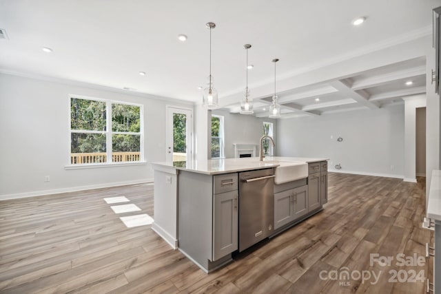 kitchen featuring gray cabinetry, stainless steel dishwasher, light hardwood / wood-style floors, and a kitchen island with sink