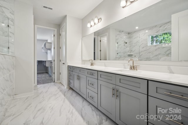 bathroom featuring tiled shower and vanity