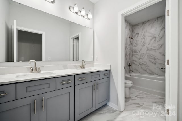 full bathroom featuring vanity, tiled shower / bath, and toilet