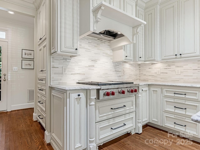 kitchen with stainless steel gas stovetop, premium range hood, backsplash, light stone countertops, and ornamental molding