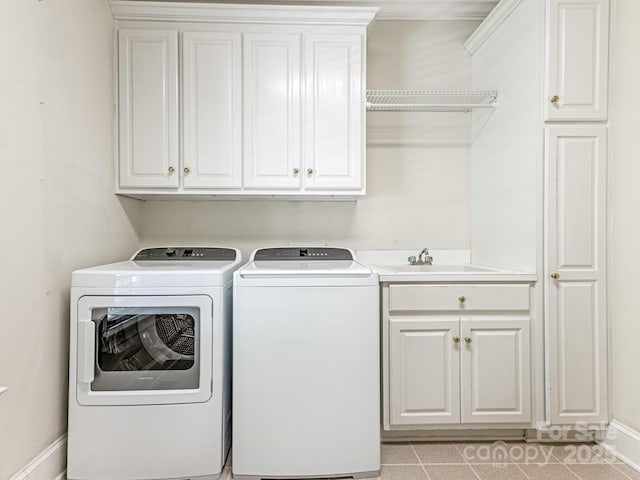 laundry room with cabinets, light tile patterned floors, sink, and independent washer and dryer