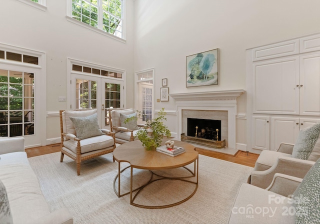 4301 Fairview Oaks Dr, Charlotte, NC 28211 - living room with french doors, light wood-type flooring, a towering ceiling, and a high end fireplace