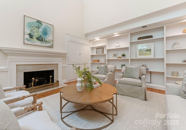 4301 Fairview Oaks Dr, Charlotte, NC 28211 - living room with light wood-type flooring, a towering ceiling, a premium fireplace, and built in shelves