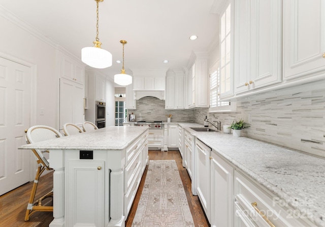 4301 Fairview Oaks Dr, Charlotte, NC 28211 - kitchen featuring a breakfast bar area, white cabinets, dark wood-type flooring, stainless steel appliances, and a center island