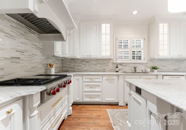 4301 Fairview Oaks Dr, Charlotte, NC 28211 - kitchen featuring stainless steel gas cooktop, wall chimney range hood, ornamental molding, white cabinets, and a sink