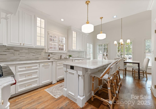 4301 Fairview Oaks Dr, Charlotte, NC 28211 - kitchen featuring white cabinets, backsplash, glass insert cabinets, a chandelier, and recessed lighting