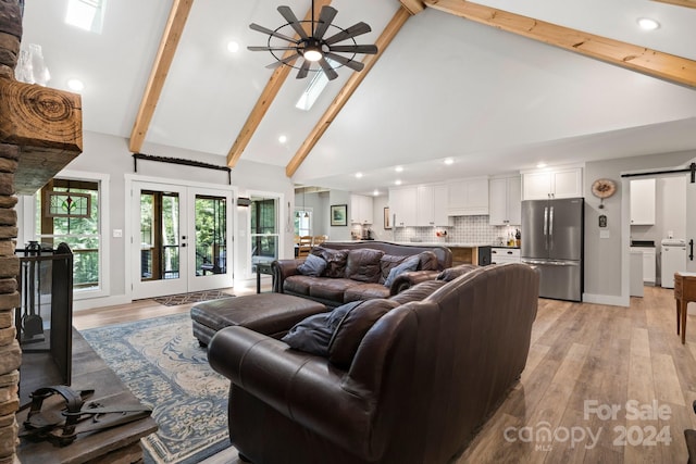 living room with high vaulted ceiling, ceiling fan, light hardwood / wood-style floors, and beam ceiling