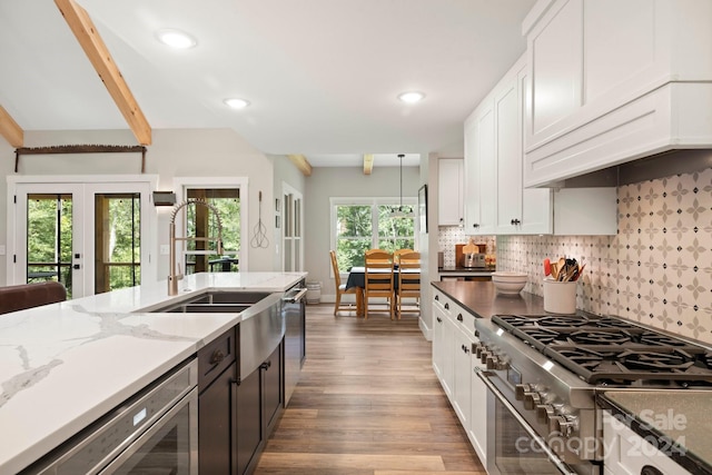 kitchen featuring plenty of natural light, backsplash, appliances with stainless steel finishes, and light hardwood / wood-style floors