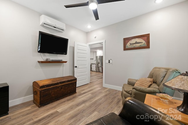 living room with ceiling fan, light wood-type flooring, and a wall unit AC