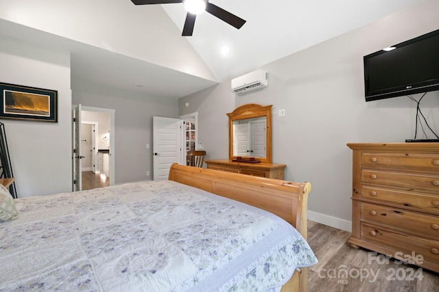 bedroom with ceiling fan, light wood-type flooring, a wall unit AC, and lofted ceiling