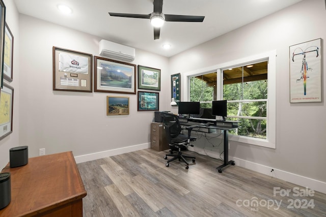 office area featuring ceiling fan, a healthy amount of sunlight, light wood-type flooring, and an AC wall unit