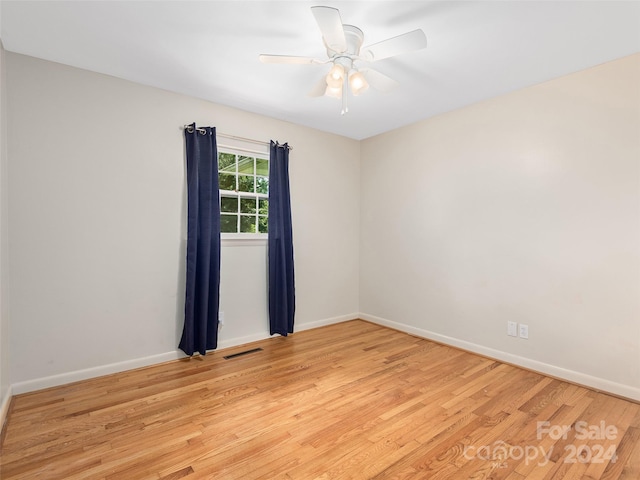 empty room featuring light wood-type flooring and ceiling fan