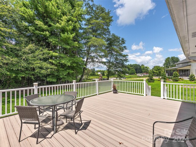 wooden deck featuring a lawn