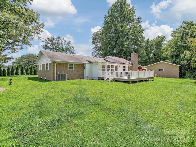 rear view of house with a deck and a yard