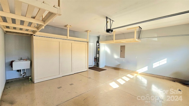 garage with electric panel, a garage door opener, and a sink